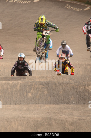 Giovani BMX bike rider i bambini a livello nazionale competizione sportiva saltare su di una rampa di Cheddar corso BMX Somerset Inghilterra Foto Stock