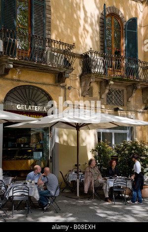 La popolazione locale a Lucca in Toscana in un momento di relax a ora di pranzo a una gelateria caffè sulla Piazza Napoleone Foto Stock