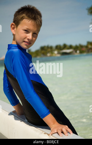 Ragazzo in piedi nel Mar dei Caraibi dopo snorkel adventure, Sud acqua Cayes riserva marina, Hopkins, Stann Creek District, Belize Foto Stock