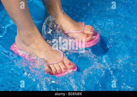 Piedi indossando flip-flop in una piscinetta per bambini Foto Stock