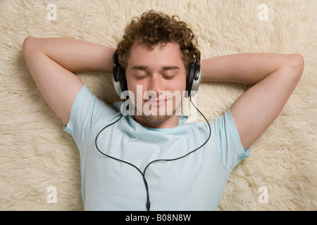 Giovane uomo ascoltare musica con le cuffie Foto Stock