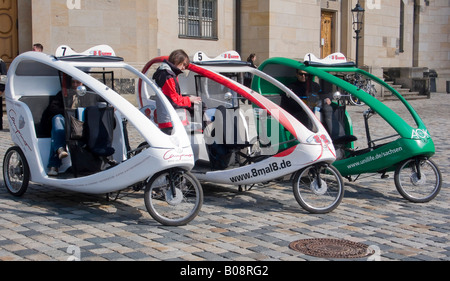 Noleggio rickshaw taxi parcheggiato su una strada acciottolata a Dresda in Sassonia, Germania Foto Stock