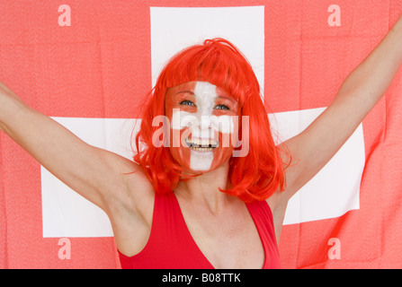 La donna come la Svizzera ventola, tifo e con la bandiera svizzera Foto Stock