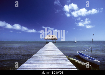 Barche accanto a una lunga dock, Caye Caulker Isola, Belize, America Centrale Foto Stock