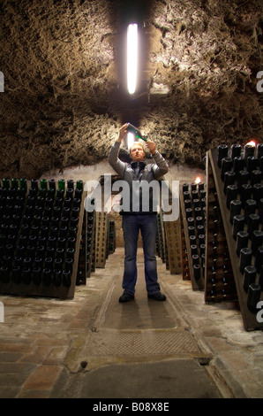 Cantiniere in una cantina a volta lo scuotimento e il controllo della qualità di champagne durante la fermentazione in bottiglia processo, Kessler Champa Foto Stock