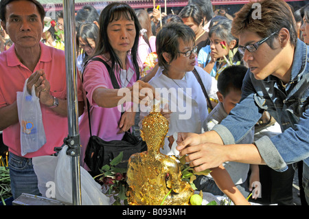 Oblazione di oro battuto e preghiere davanti al tempio di Jade-Buddha in Wat Phra Kaeo, grande palazzo, Thailandia, Bangkok Foto Stock