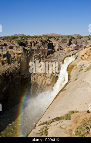 Spray a prua, parziale rainbow formata nel fondo della gola ai piedi del Augrabies Falls sul fiume Oranje, Augrabies Foto Stock