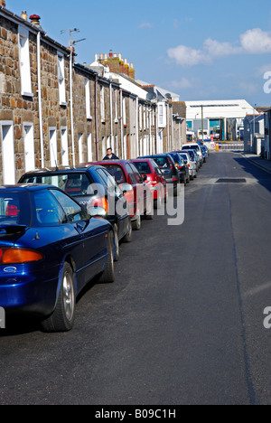 Una strada stretta con una fila di automobili parcheggiate verso il basso da una parte in camborne,cornwall,Inghilterra Foto Stock