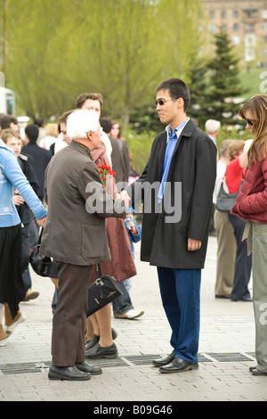 Giovane uomo ringraziare l Esercito Rosso dal veterano della Grande Guerra Patriottica su la Giornata della vittoria nel Parco della Vittoria a Mosca, Russia Foto Stock