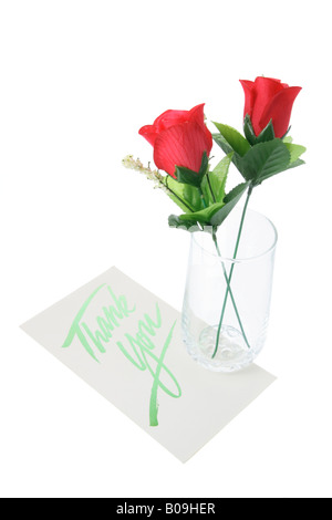 Rose rosse in vaso con biglietto di auguri Foto Stock
