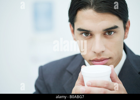 Imprenditore azienda tazza monouso, close-up, ritratto Foto Stock
