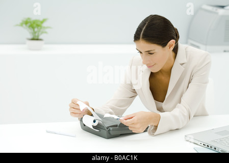 Young Professional mediante aggiunta di una macchina, tenendo il ricevimento Foto Stock