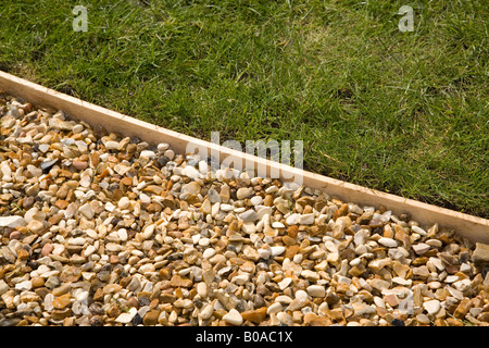 Sentiero di ghiaia con prato in legno la bordatura Foto Stock