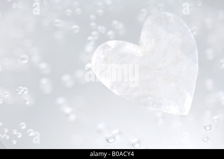 Forma di cuore e di bolle in acqua, close-up Foto Stock