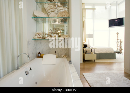 Hotel di lusso grande bagno con vasca e camera da letto in background Foto Stock
