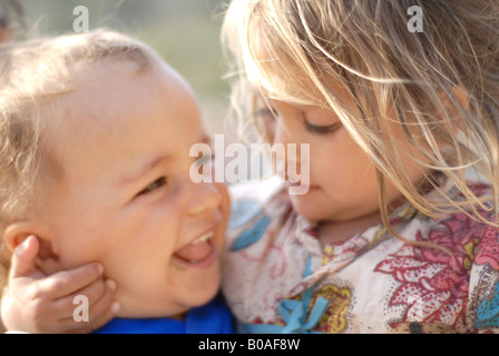 Ritratto di una bellissima gara e di razza mista piccola ragazza mezza thai abbracciando un bambino Foto Stock