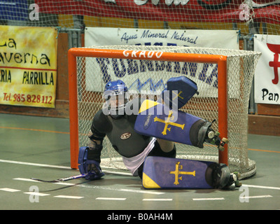 Portiere fermare la palla in un gioco di hockey a rullo Foto Stock