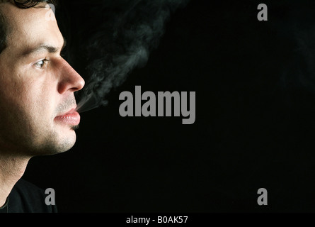 L'uomo espirando il fumo di sigaretta Foto Stock