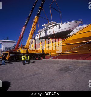 Johnson 77 luxury motor yacht superyacht nel corso di sollevare il contenitore dalla nave nel porto di Palma de Mallorca Foto Stock