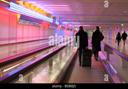 Passeggeri su un tapis roulant di un aeroporto di Monaco di Baviera, Germania Foto Stock