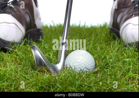 La pallina da golf nella ruvida con un ferro da stiro è dietro e i golfisti di scarpe in background Foto Stock