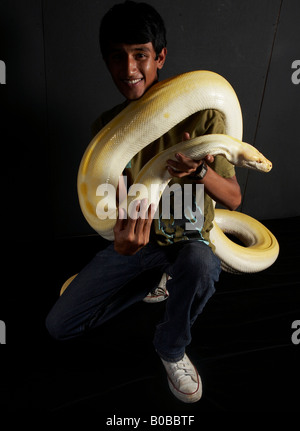 Ragazzo con enorme Albino Python intorno al suo corpo Foto Stock