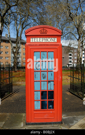 Un rosso K2 telefono scatola dipinta blu all'interno, in piedi all'ingresso di un parco circondato da consiglio appartamenti nel quartiere di Bloomsbury, Londra Foto Stock