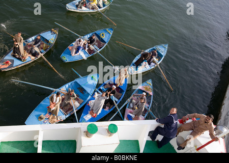 I battellieri su molte piccole barche sul Nilo provare a tentare i passeggeri delle crociere per acquistare merci Foto Stock