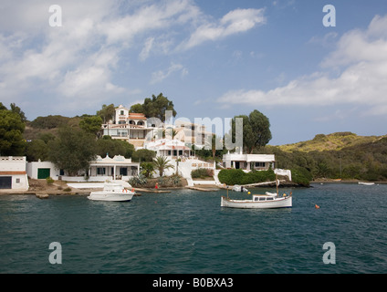 Case sulla sponda nord del porto di Mao (Mahon), Menorca, isole Baleari, Spagna si affacciano le tante barche ormeggiate nelle vicinanze. Foto Stock