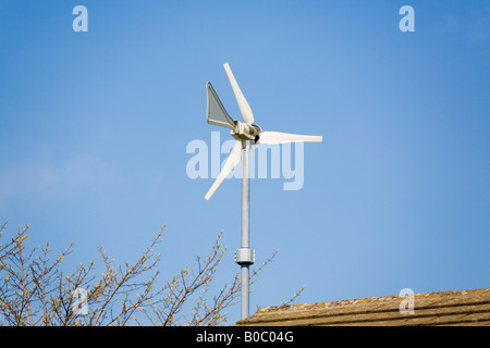 Wndsave micro turbine eoliche montate su casa parete sopra il tetto contro il cielo blu Windsave 1200 si connette alla rete nazionale di coda della lama Foto Stock