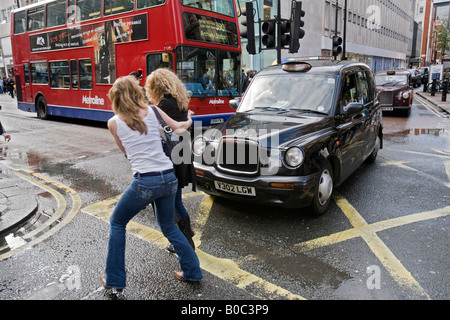 Due donne evitare un taxi su Oxford Street, Londra Foto Stock