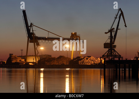 Ricaricamento di gru di un porto di sera, Wismar in Germania Foto Stock