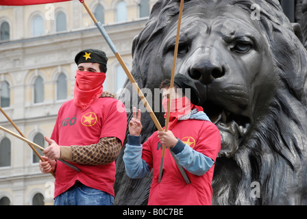 Due turco MLKP marxista leninista partito comunista membri vestito di rosso in piedi sotto i Lions in Trafalgar Square Foto Stock