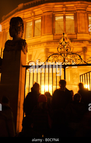 [Sheldonian Theatre] illuminata di notte, Luminox Festa del Fuoco guardato da persone al cancello di ingresso, 'Broad Street', Oxford, England, Regno Unito Foto Stock