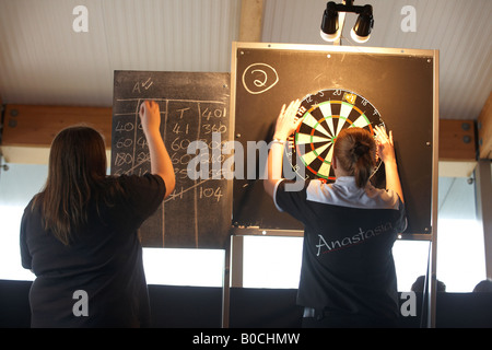 Onorevoli freccette champion Anastasia Dobromyslova recupera la sua freccette dopo aver gettato le frecce in un knock out gioco di 501 Foto Stock