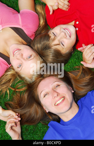 Ritratto di una madre di famiglia e bambini sdraiati sull'erba in un parco Foto Stock