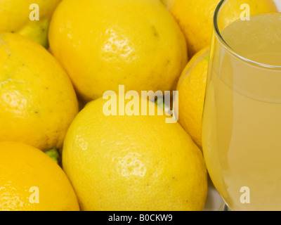 Bicchiere di limonata naturale con molti limoni Foto Stock