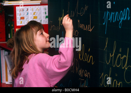 Una ragazza giovane studente scrive tedesco in gesso su una lavagna di una scuola in Liechtenstein Foto Stock