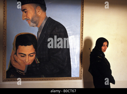 A Kabul un dipinto del presidente Hamid Karzai che mostra che si sta prendendo cura di womens destra Foto Stock