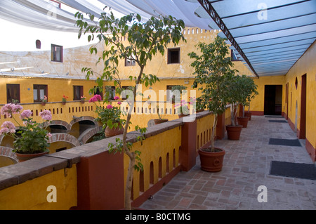 Cortile interno del Camino Real hotel in Puebla, Messico. Circondato da colonne antiche, il tetto coperto da una gigantesca ombra. Foto Stock