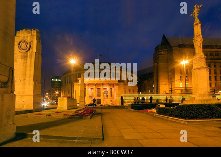 Il metro tram che passa la rotunda-style della Biblioteca centrale di Manchester in prima serata Foto Stock