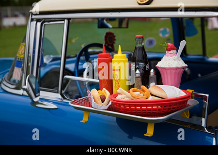 Un vassoio di vetro su un classico americano auto usati per il fast food pasti da asporto acquistato a guidare in film. Foto Stock