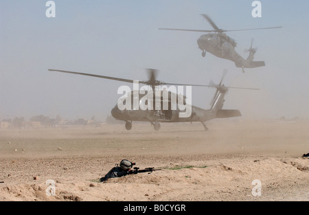 Due U S Army UH 60 Black Hawk elicotteri Blow up nubi di polvere come essi entrano in una zona di atterraggio a Samarra in Iraq Foto Stock