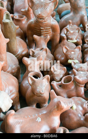 Stile azteco souvenir cani - o forse il coyote in vendita in un mercato di strada in Cholula, Messico. Alcuni hanno il granturco dolce nelle loro bocche. Alcuni forse lampade a olio Foto Stock