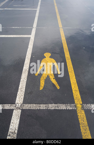 La segnaletica stradale della figura umana che mostra passaggio pedonale attraverso il parco auto Foto Stock