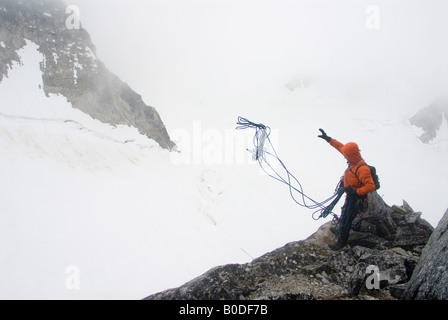 Scalatore gettando il rappel funi nella nebbia sul trono, piccola Svizzera, Pika ghiacciaio, Alaska Foto Stock