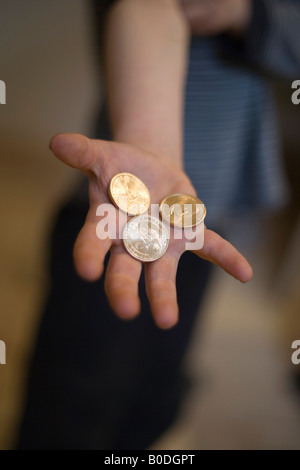 La mano di cinque anni di bambino holding US dollar monete e quarti salvato dal salvadanaio Foto Stock