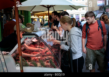 Effettuare acquisti presso bancarelle prodotti alimentari nel mercato di Borough, Londra, Inghilterra. Foto Stock