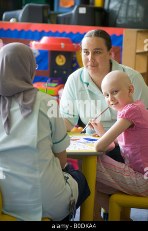 Una giovane ragazza si siede con pittura a sua cura dei lavoratori in ospedale unità bambini REGNO UNITO Foto Stock