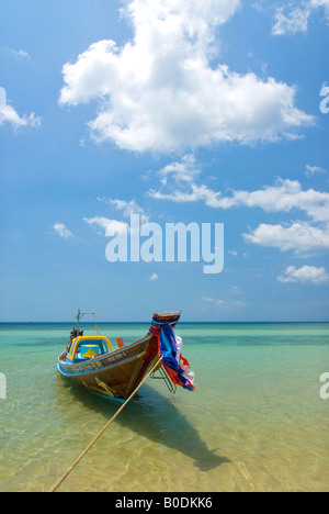 Un piccolo villaggio barca attende il suo proprietario come il mare giri sulle rive di questo paradiso tropicale Foto Stock